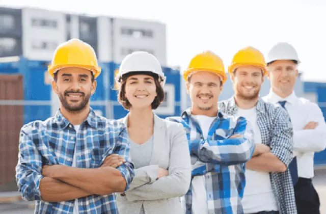 A line of builders wearing hardhats, crossed arms and looking happy